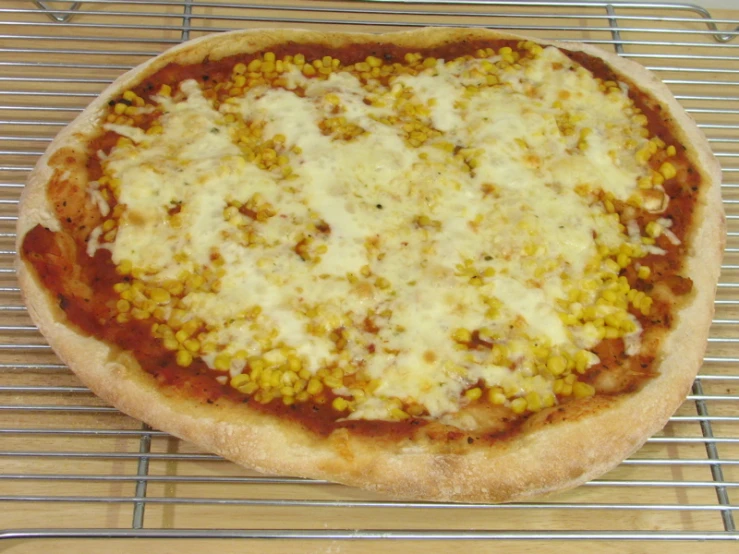 a pizza with corn is on the rack