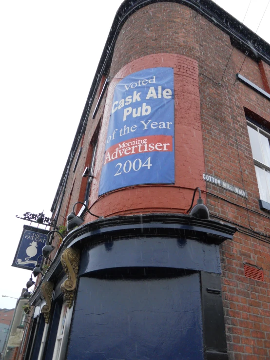 a brick building with a sign saying the pub in front