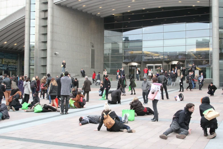 many people are standing and laying on the pavement