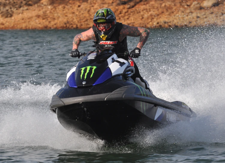 a man wearing an oncoming helmet riding on a jet ski