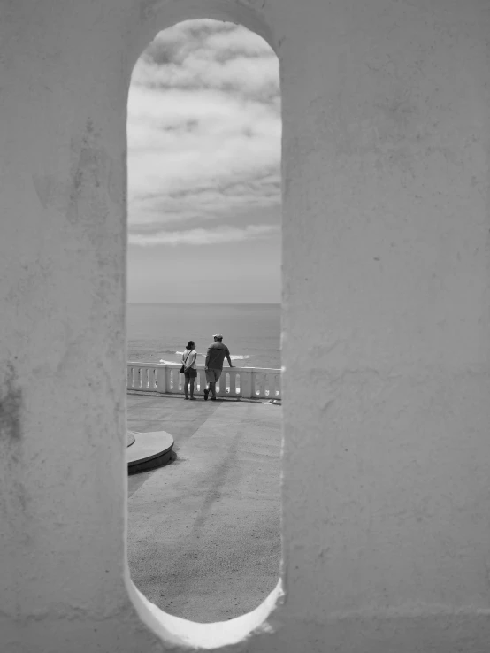 a couple of people standing at the end of a dock