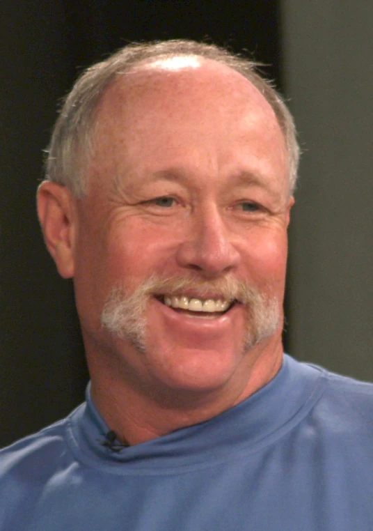 a man with a beard smiles for the camera