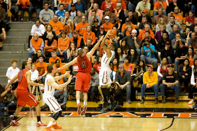 the basketball players are fighting for the ball