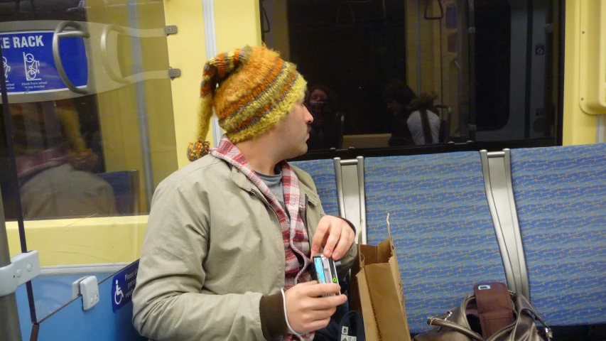 a man is standing on the subway, holding soing