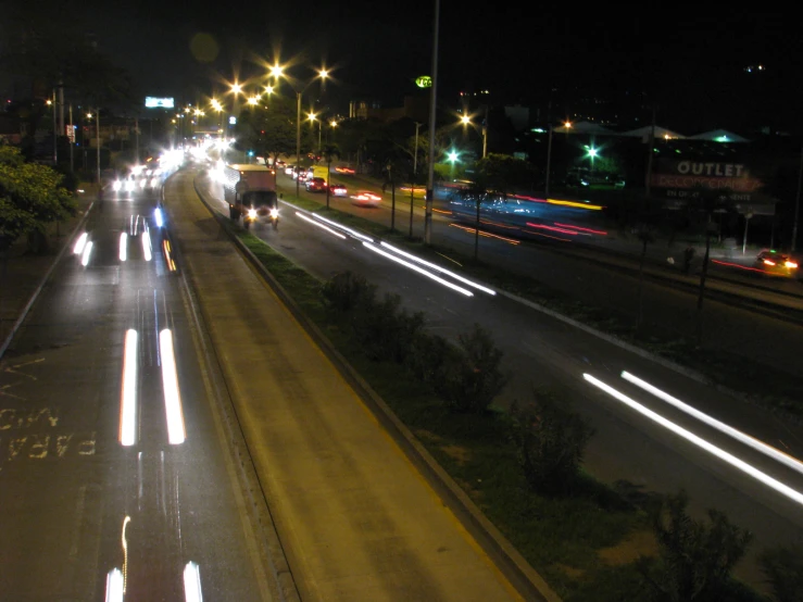 city lights streak through the night sky above a highway