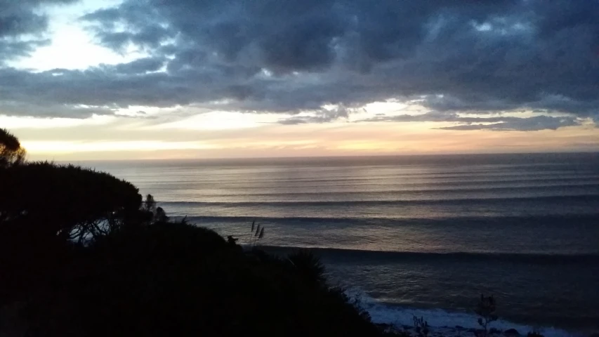 clouds are over the ocean as dark smoke from the ocean is visible