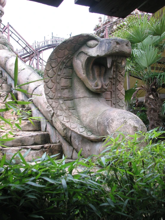 a lion like figure made out of cement surrounded by vegetation