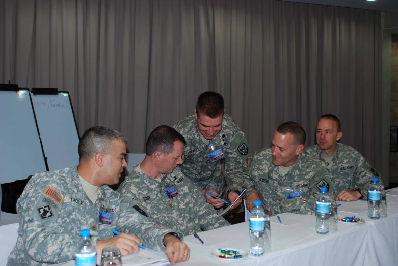 four military officers are having a good time at a meeting