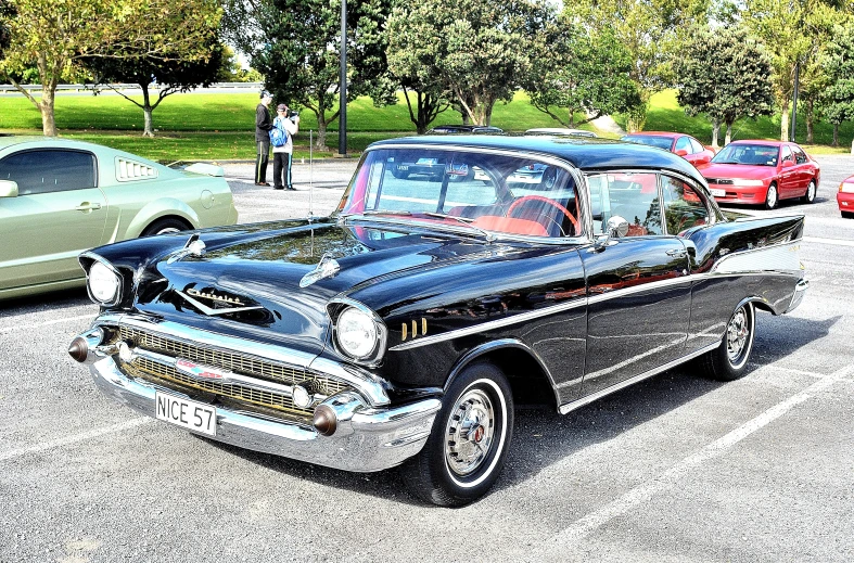 an old model black car parked next to other antique cars