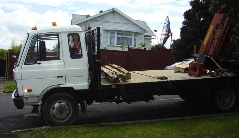 a utility truck is hauling lumber in the driveway