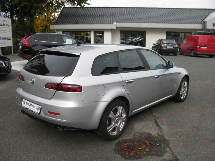 the silver sports car is in front of a house