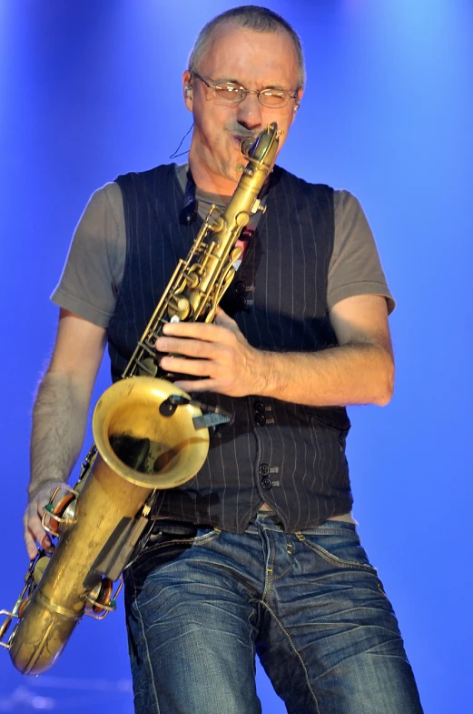 a man holding up a saxophone in his right hand
