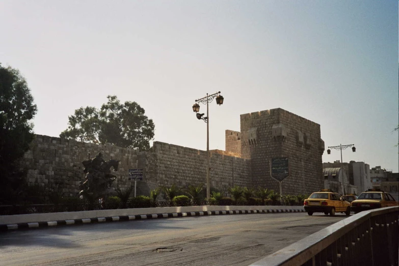 the cars are driving in front of the bricked wall