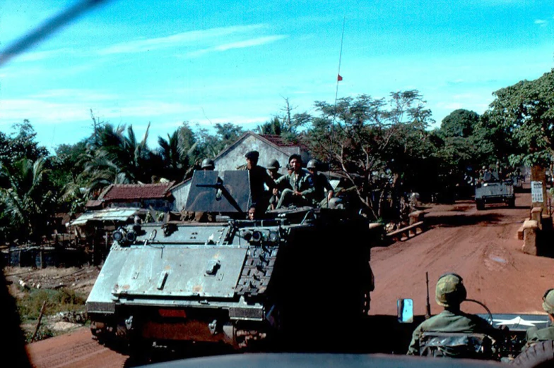 the military men are in an old truck on a road