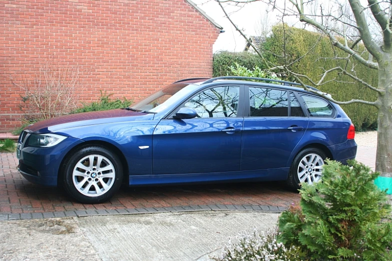 a blue vehicle is parked on a brick driveway