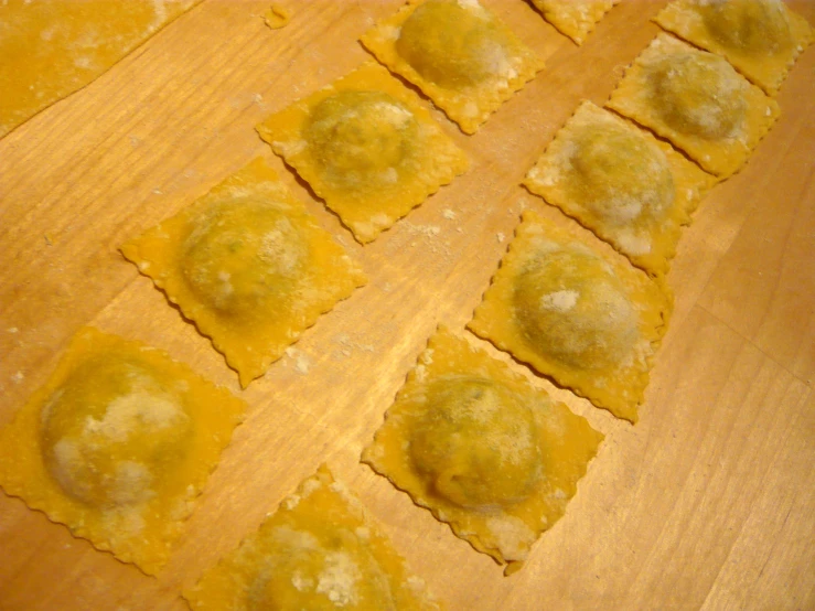 the raw homemade ravioli sits on the wooden table