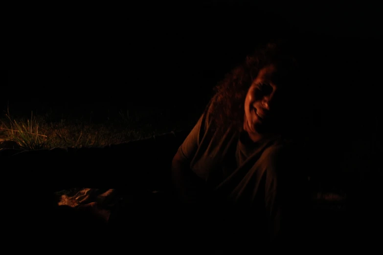 a person in the dark sitting on the ground