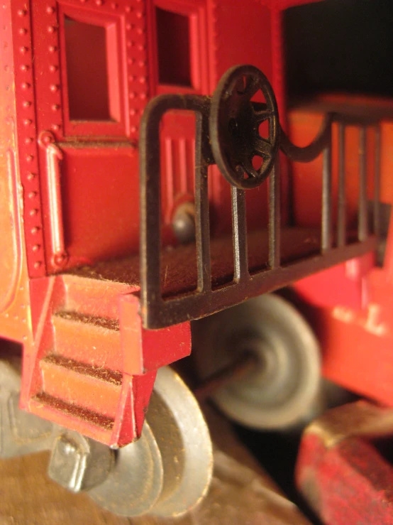 a toy train car on a table next to wheels