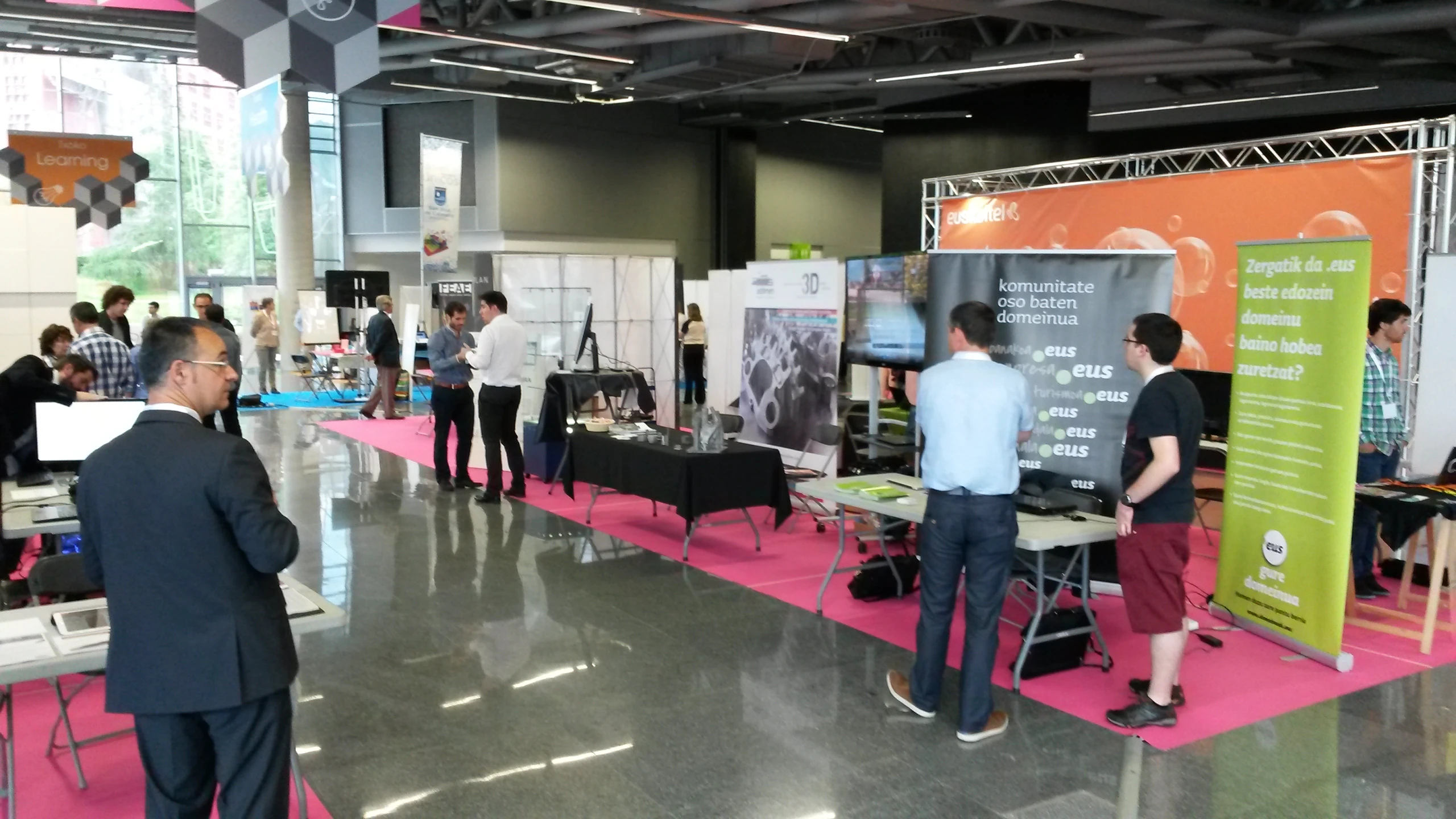 many people are standing near a poster display