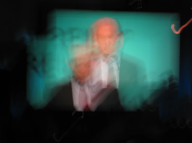 a blurry image of a man with a microphone