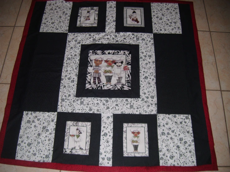 a quilted black and white wall hanging on a floor