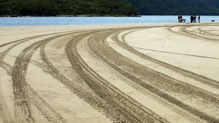 a dirt road going into the distance on the beach