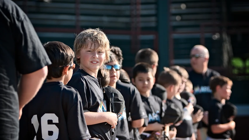 several children are lined up in black uniforms