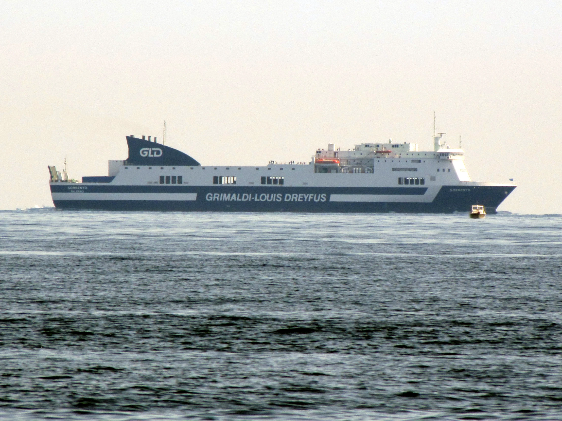 a large boat traveling down the ocean near a tug boat