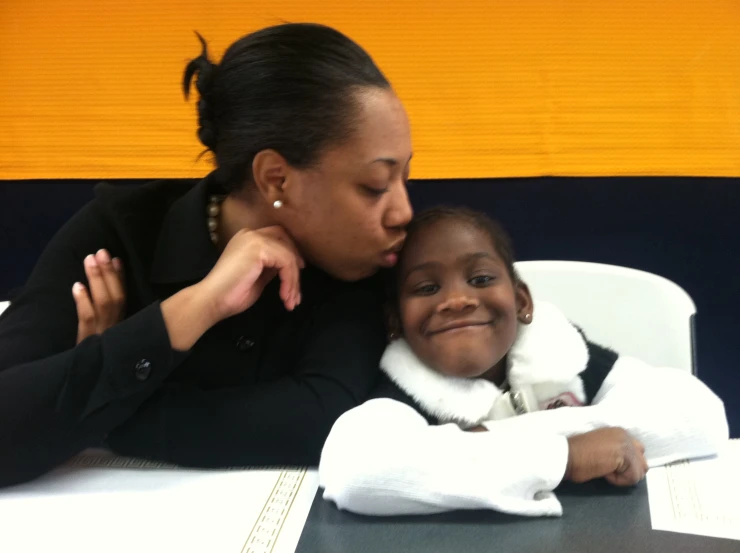 a girl gets her face brushed by her mother