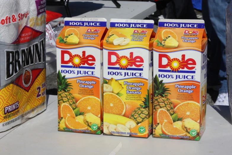 three dole juice cartons are stacked on a table