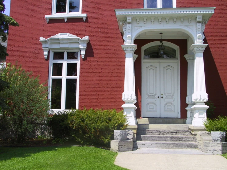 a white door sits on a red brick building