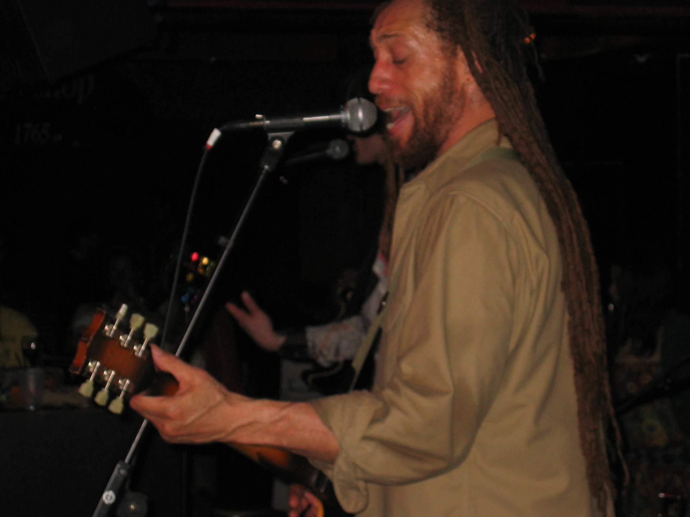 a man with long dreadlocks is playing a guitar