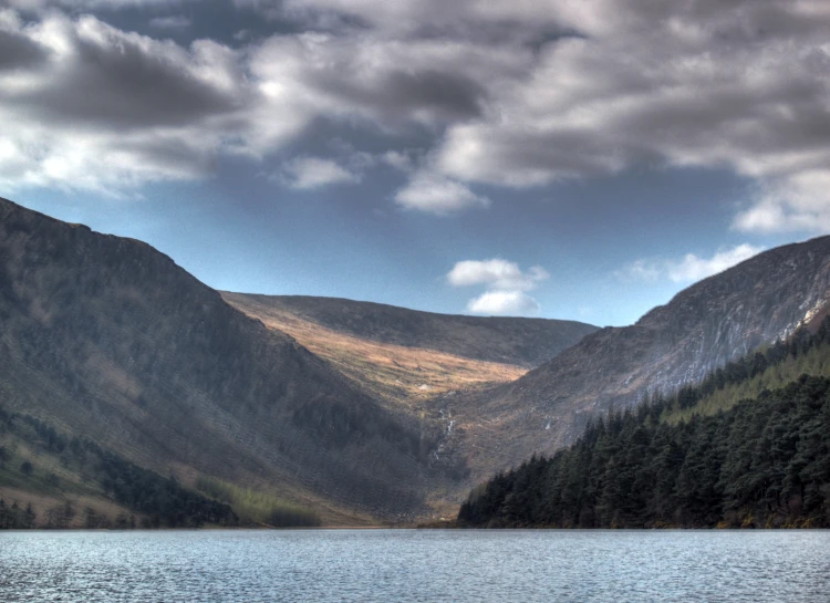 the view from a distance of mountains with forest on it