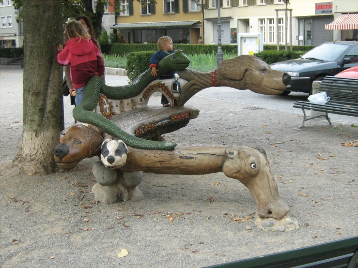 two children are riding on a fake animals playground