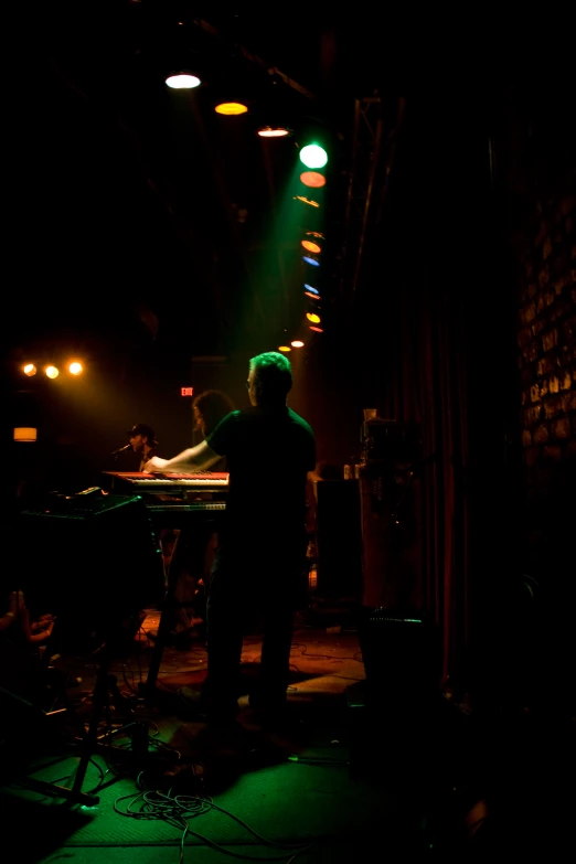 a man standing in front of a keyboard in a dark room