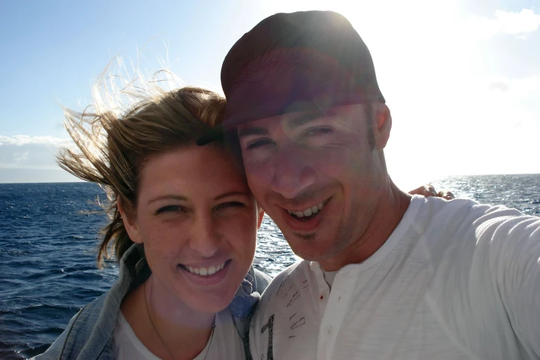 the couple is smiling on a boat in the ocean