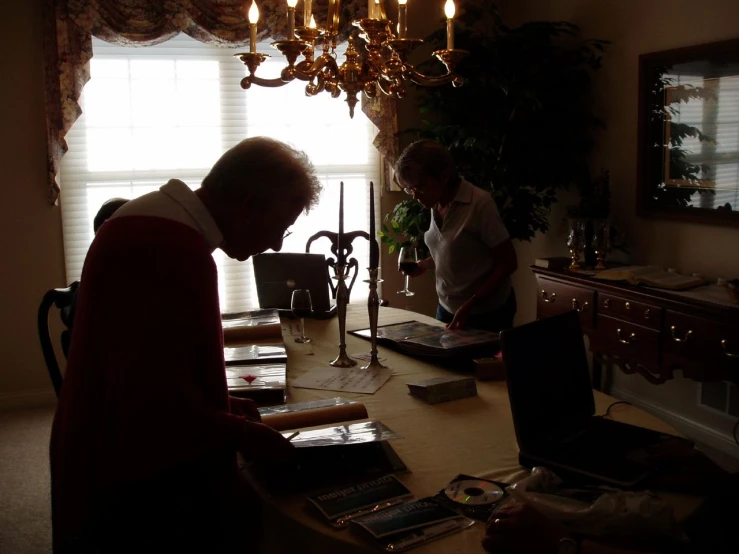 two older men working on a project at a dining room table