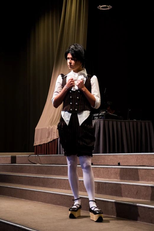 a young man dressed in historical clothing standing on stage