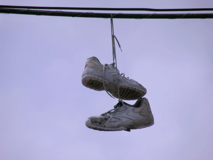 a pair of shoes hanging from power lines