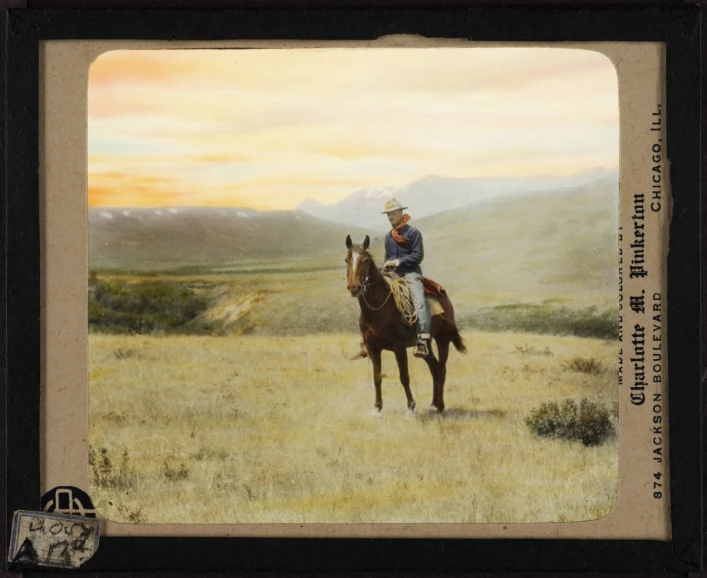 an old pograph of a cowboy riding his horse