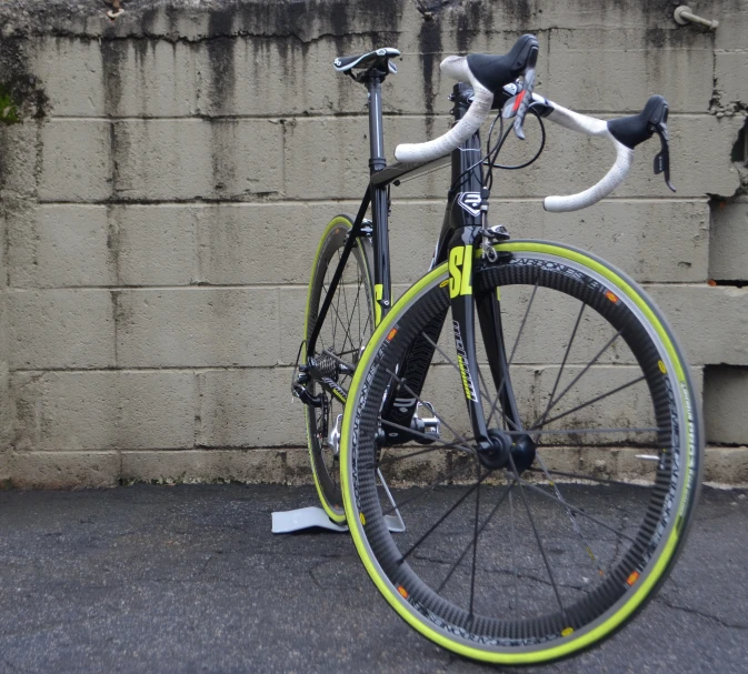 a bicycle is leaning against a wall near a parking meter