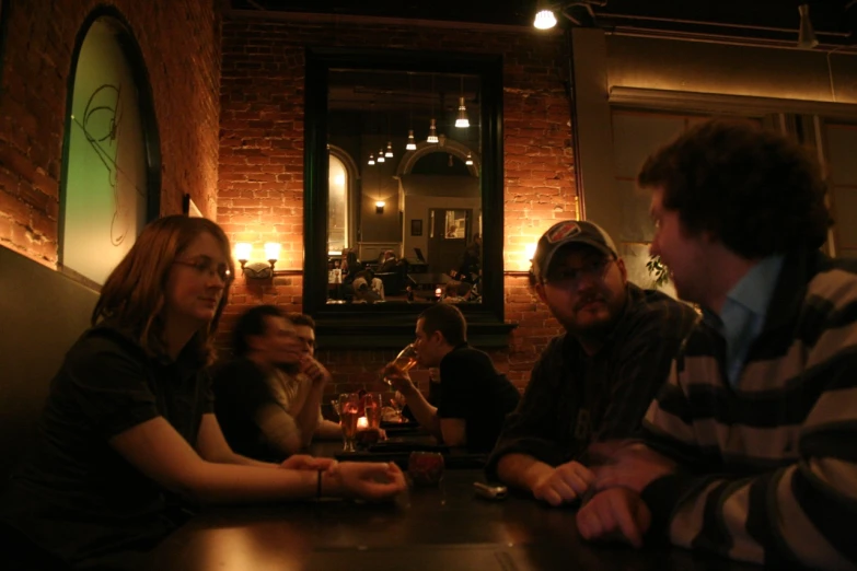 people sitting around a bar having drinks in the dark