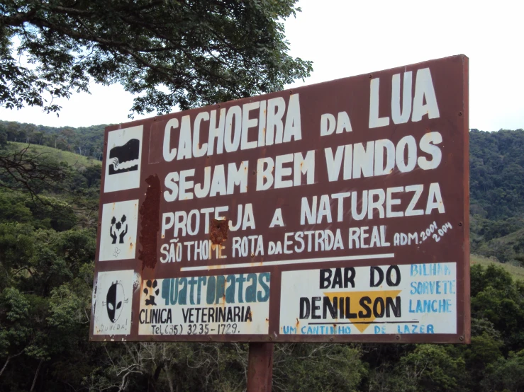 an advertising sign in spanish near some trees