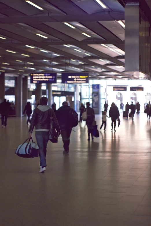 a crowd of people are walking through an airport