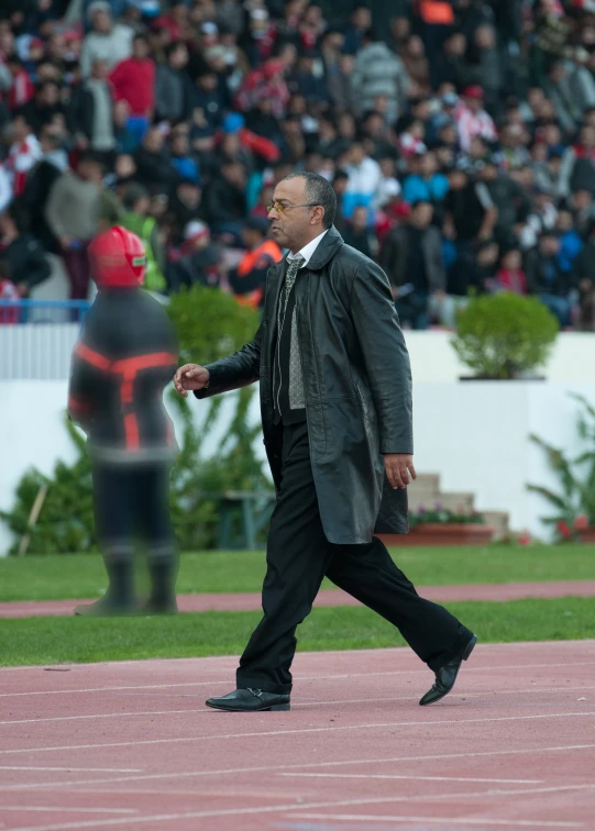 man in black walking on a pink path at an outdoor event