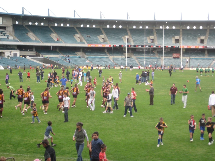 a crowded soccer field in front of an empty stadium