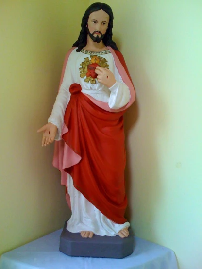 a statue of jesus with a red cape