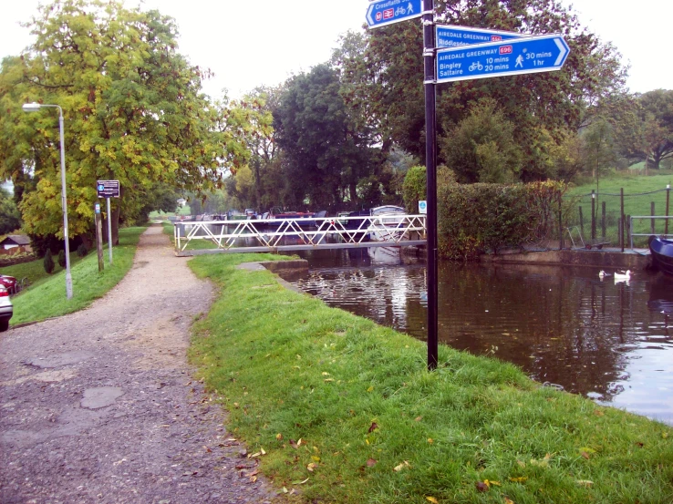 a small boat in a river on the side of a road