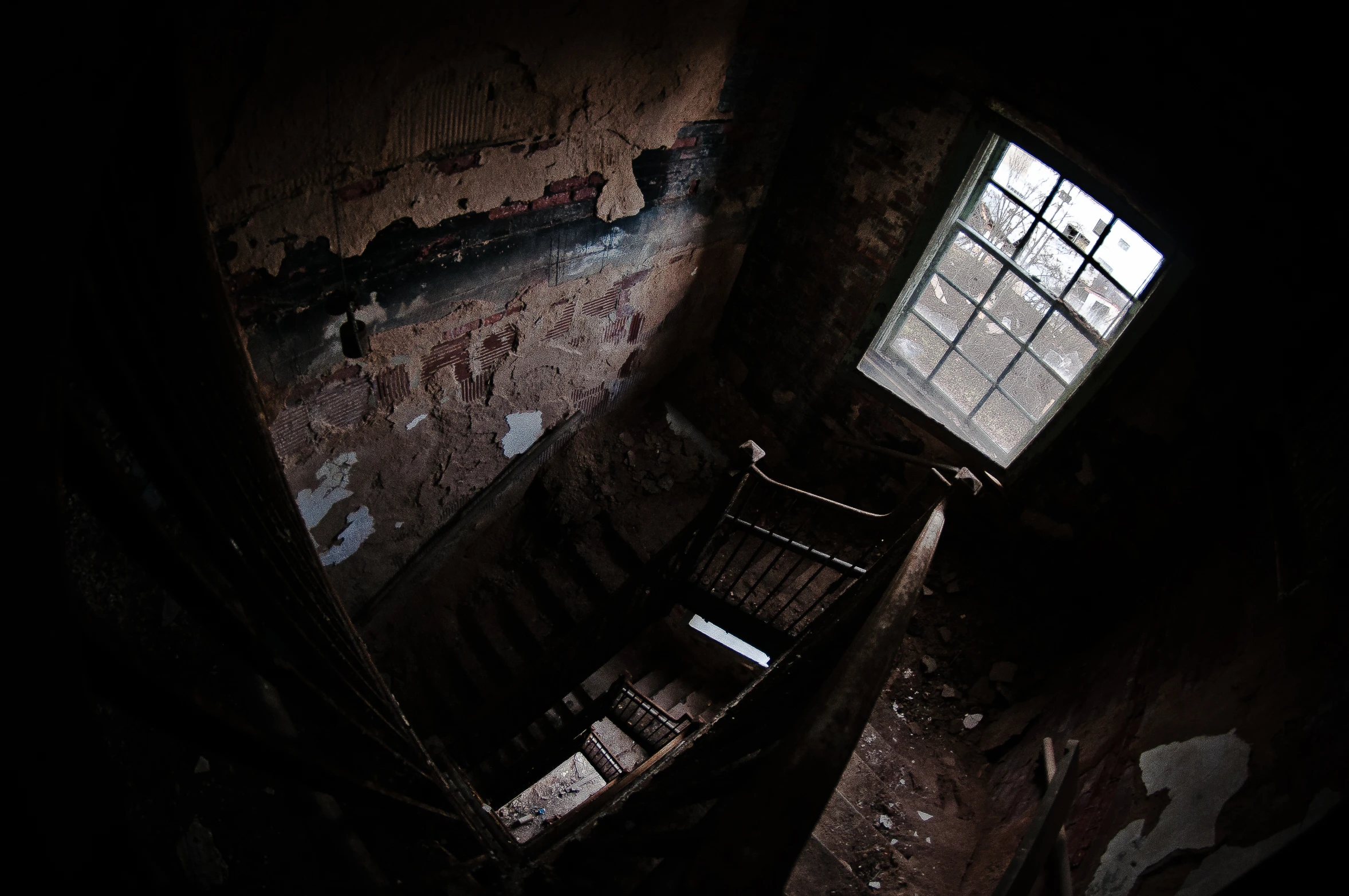 looking down from an old stairway up into a second story window