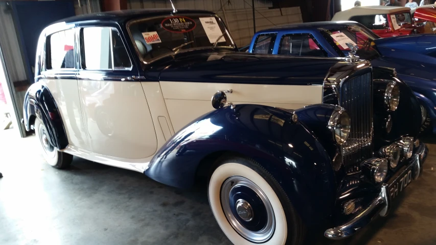 a blue and white car is parked next to other cars